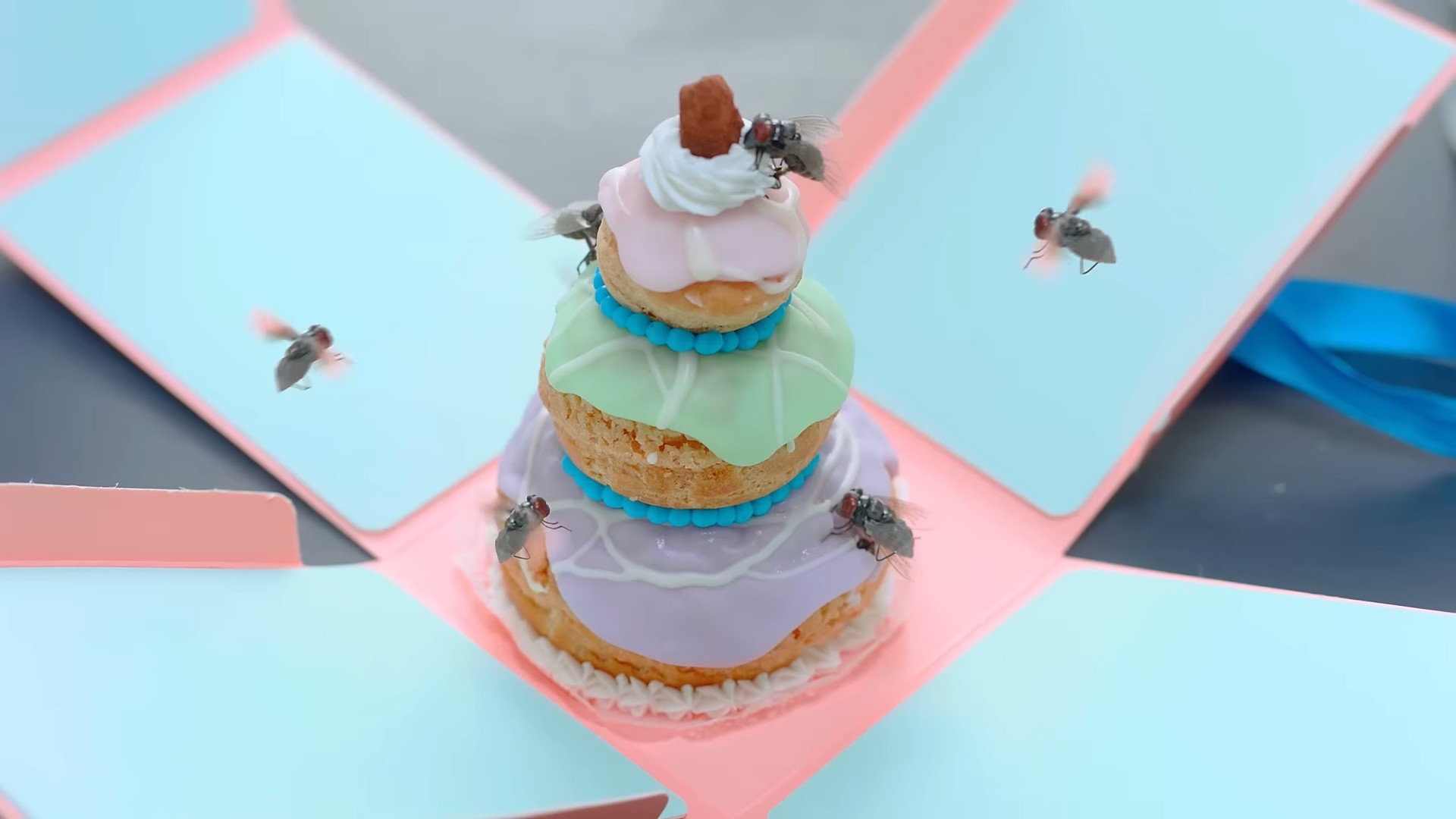 An elaborate pastry with flies on it.